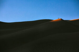 Hikers survey the dune landscape just as the sun sets on Great Sand Dunes National Park