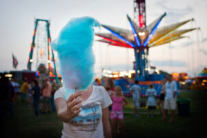 A mast of blue cotton candy stands between the camera and the holder